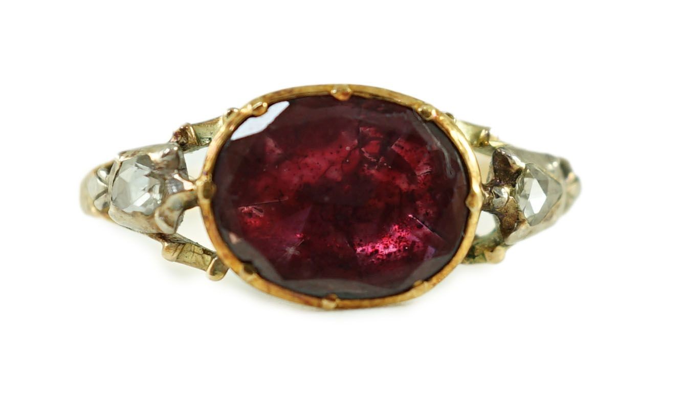 A George III gold, foil backed garnet and rose cut diamond set three stone ring